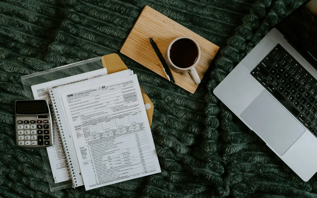 Escriptori amb un portàtil, factures i una calculadora